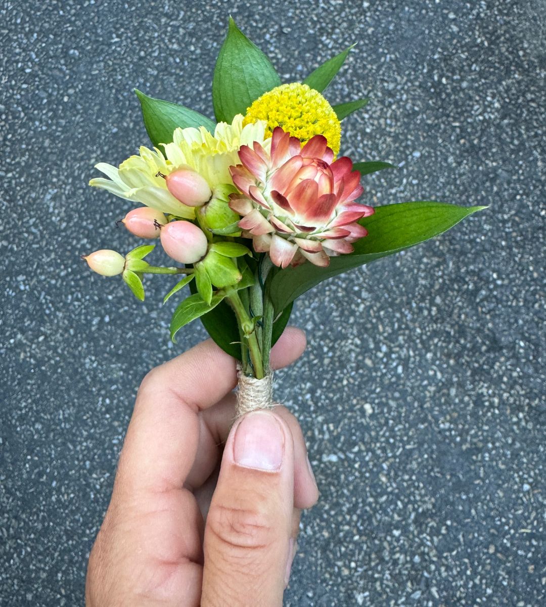 Hand holding a boutonniere