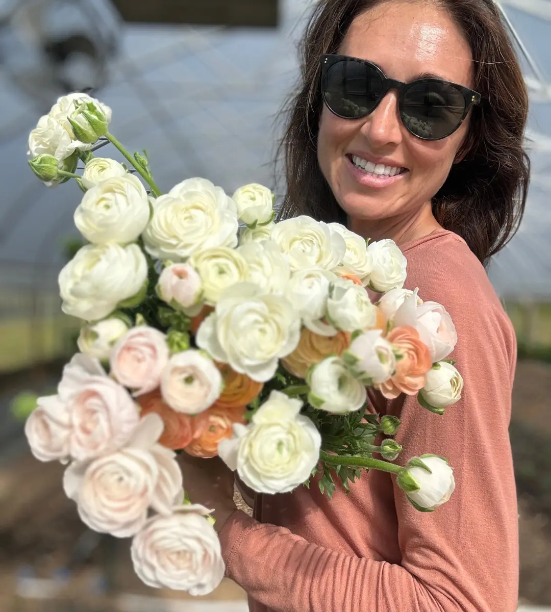 Founder of Winters Farm Florals, Dani, holding bunch of white and pale pink flowers