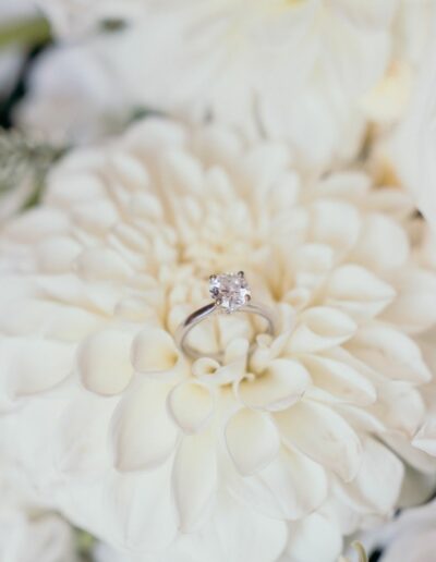 Wedding Ring set on a white dahlia flower inside a bouquet