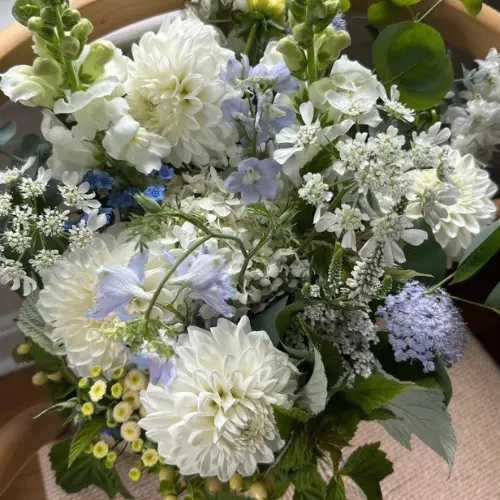 Up close view of a flower arrangement with white and blue flowers by Winters Farm Florals