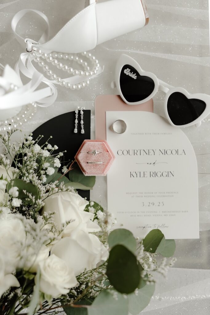 Flat lay design of a wedding invitation with white and green florals by Winters Farm Florals