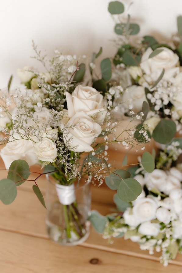 Bouquets sitting in a vase by Winters Farm florals in green and white