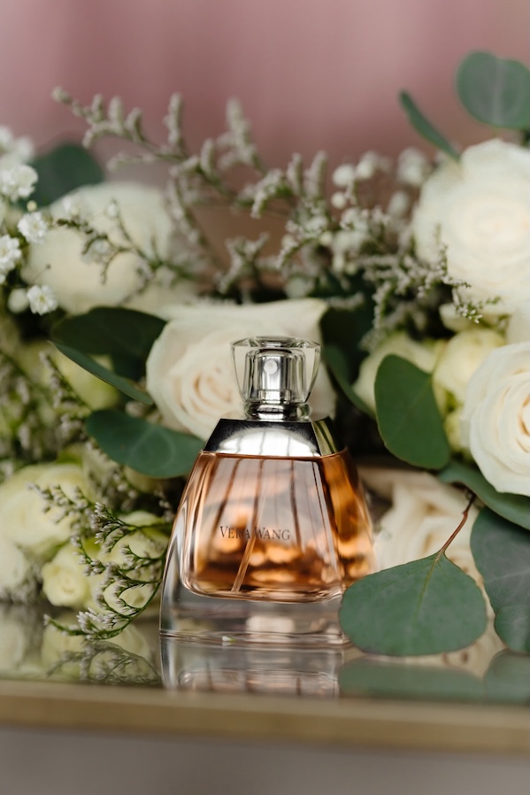 Perfume for the bride's wedding day surrounded by white and green florals by Winters Farm Florals