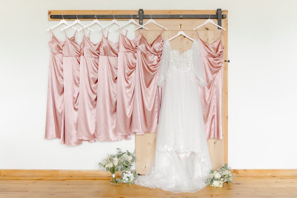 Brides dress and bridesmaids dresses with bouquets in green and white at the bottom