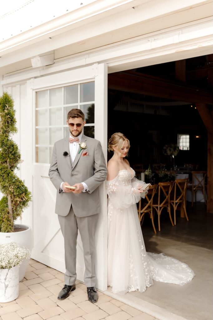 Groom and Bride reading vows to each other before the ceremony, groom wearing a boutonniere by winters farm florals
