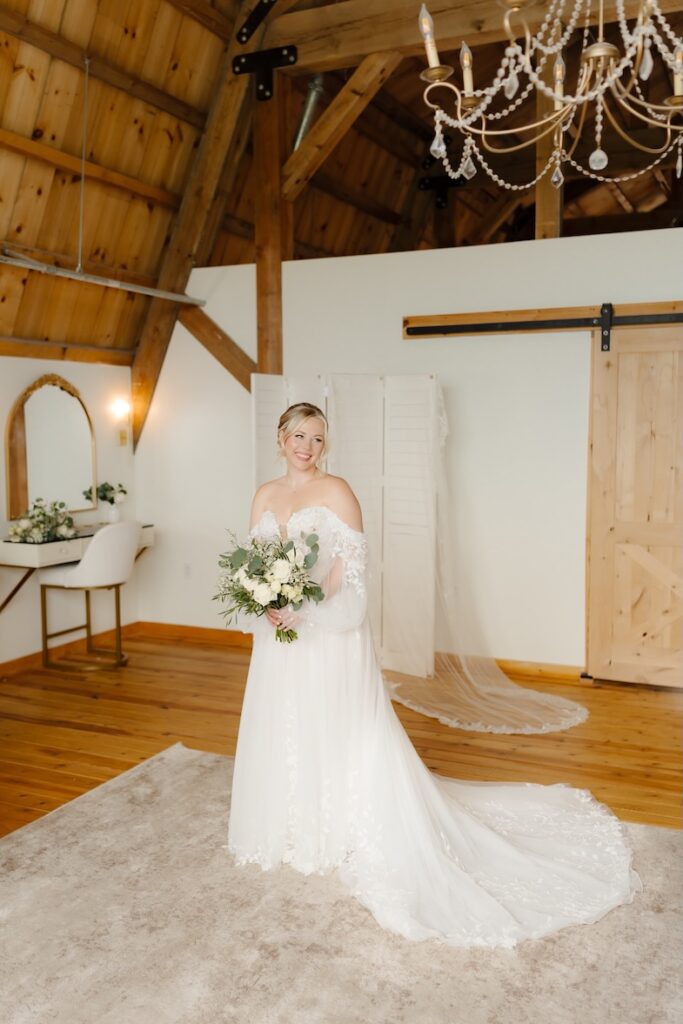 Bride smiling in the getting ready area at Breckenridge Barn with a bouquet by Winters Farm Florals