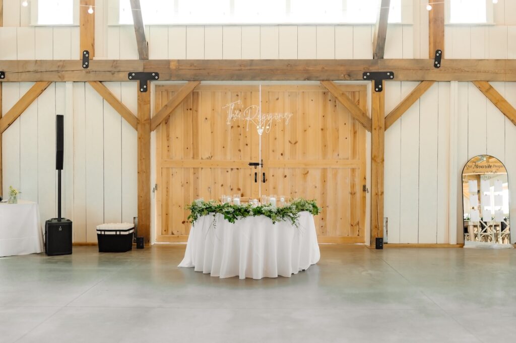 Breckenridge Barn Sweetheart Table with Loose Greenery on the Table by Winters Farm Florals