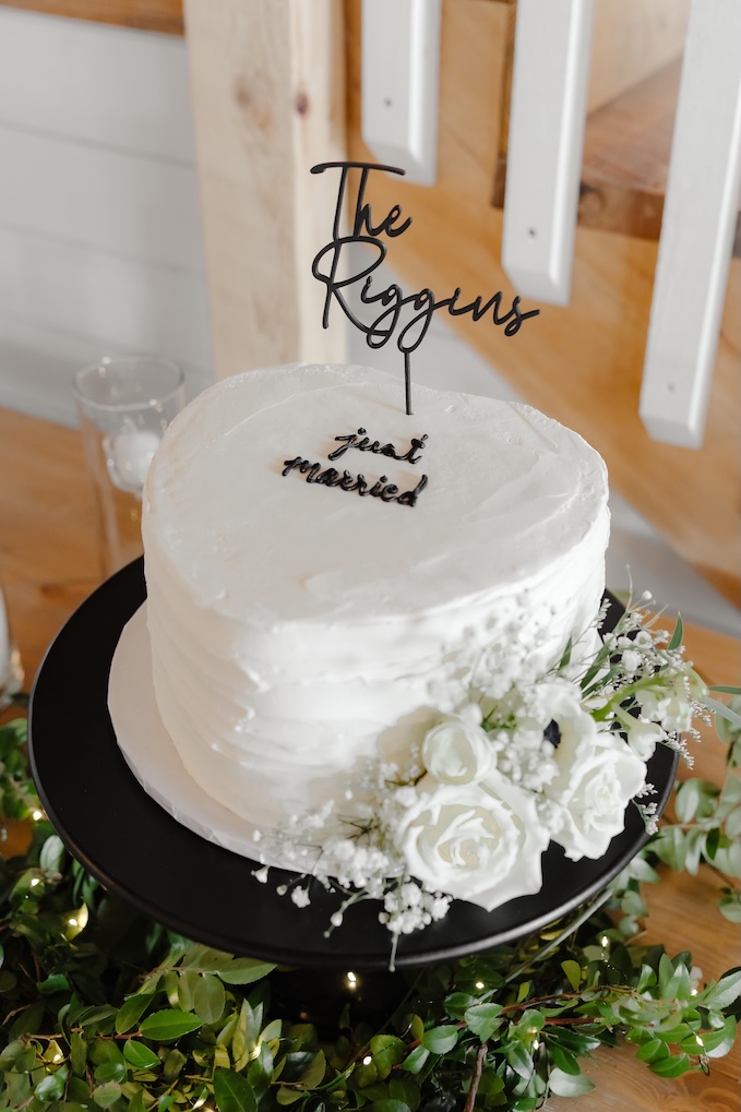 Close up of simple white cake with florals added by Winters Farm Florals at Breckenridge Barn reception